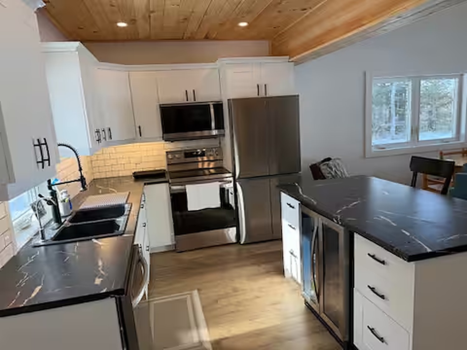 Full modern kitchen with white cabinets and black marble