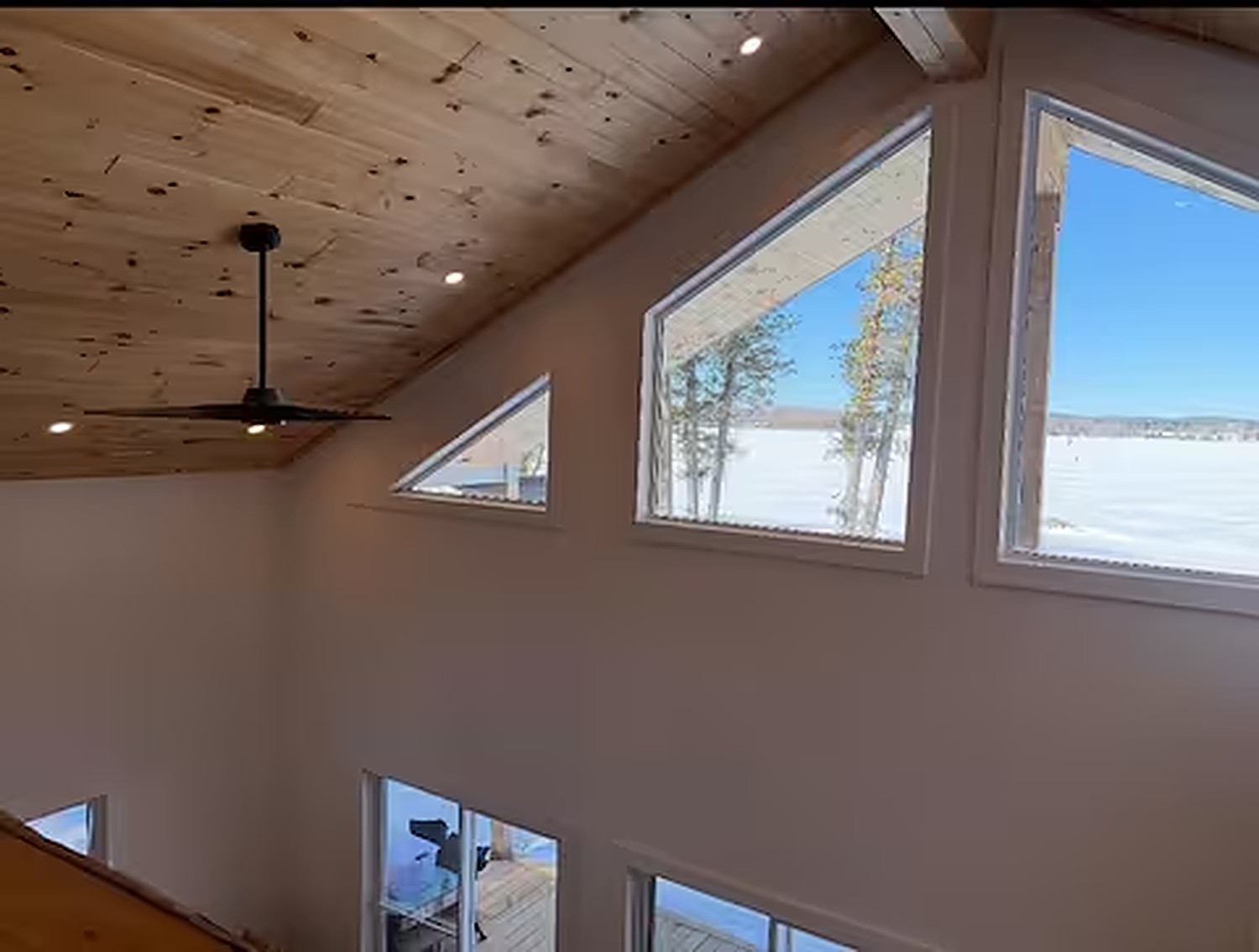 Cathedral windows with panoramic lake views over the living area