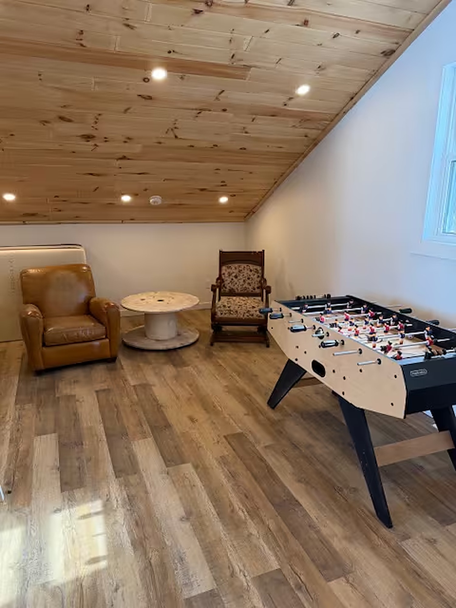 Loft game room with foosball table and leather armchairs